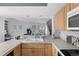 Kitchen featuring bar-top seating, tile countertops, wooden cabinets and an open view of the living room at 1929 S Xanadu Way, Aurora, CO 80014