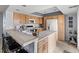 Kitchen featuring light wood cabinets, tile countertops with bar seating, and modern appliances at 1929 S Xanadu Way, Aurora, CO 80014