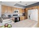 Kitchen featuring light wood cabinets, tile countertops, ample storage, and modern appliances at 1929 S Xanadu Way, Aurora, CO 80014