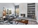 Bright living room with a cozy seating area, a fireplace, and built-in shelving at 1929 S Xanadu Way, Aurora, CO 80014