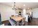 Open concept kitchen and dining area, with rustic wood table, chandelier, and stainless steel appliances at 469 S Olathe St, Aurora, CO 80017