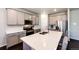 Spacious kitchen featuring gray cabinets, stainless appliances, large island with seating, and white countertops at 469 S Olathe St, Aurora, CO 80017