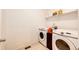 Functional laundry room equipped with a washer, dryer, and shelving for storage at 469 S Olathe St, Aurora, CO 80017