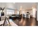 Open-concept living area featuring dark hardwood floors, a gray sectional sofa, and a view of the kitchen at 469 S Olathe St, Aurora, CO 80017