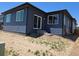 Exterior of a new navy blue house with a sliding glass door and an unfinished yard at 418 Grey Rock St, Brighton, CO 80601