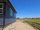Side view of a navy blue home with large windows and an unfinished yard at 418 Grey Rock St, Brighton, CO 80601