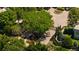 Aerial view of gated community entrance shows mature trees, lush landscaping, and paved driveways with roundabout at 400 S Steele St # 64, Denver, CO 80209