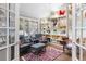 Cozy sitting room with built in display shelving, shuttered windows, and comfortable chairs at 400 S Steele St # 64, Denver, CO 80209