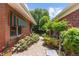 A stone paver walkway is nestled between two brick buildings and abundant colorful landscaping, creating a charming outdoor space at 400 S Steele St # 64, Denver, CO 80209