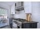 Modern kitchen with a stainless steel gas range, custom vent hood, and subway tile backsplash at 855 33Rd St, Boulder, CO 80303
