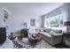 Cozy living room with a neutral sofa, large window with sheer curtains, and a glass-topped coffee table at 855 33Rd St, Boulder, CO 80303