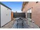 Backyard patio with brick home has a stone patio, black metal furniture and a black and white outdoor rug at 12708 W Virginia Ave, Lakewood, CO 80228