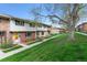 Townhome exterior features a green lawn, sidewalk and mature trees at 12708 W Virginia Ave, Lakewood, CO 80228