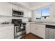 Bright kitchen featuring stainless steel appliances and white cabinetry with lots of natural light from the window at 12708 W Virginia Ave, Lakewood, CO 80228