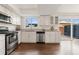 Open kitchen with stainless steel appliances, light countertop, white cabinets, and a sliding door to the back patio at 12708 W Virginia Ave, Lakewood, CO 80228