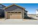 Beige garage door and concrete driveway on a gray home at 2263 Serenidad St, Brighton, CO 80601