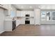 Bright kitchen featuring white cabinets, stainless appliances, and wood-look floors at 2263 Serenidad St, Brighton, CO 80601