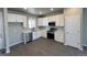 Modern kitchen featuring white cabinets, stainless steel appliances and gray wood flooring at 2263 Serenidad St, Brighton, CO 80601