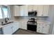 Updated kitchen showcasing stainless steel appliances, quartz countertops, and white cabinetry at 2263 Serenidad St, Brighton, CO 80601