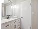 Bright bathroom with a white vanity, black hardware, and updated lighting at 7351 S Sheridan Ct, Littleton, CO 80128