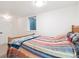 Cozy bedroom featuring a comfortable bed with colorful striped blankets and soft carpeting at 7351 S Sheridan Ct, Littleton, CO 80128