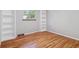 Bright bedroom with hardwood floors, built-in shelves, and a view of the backyard at 7351 S Sheridan Ct, Littleton, CO 80128