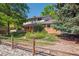 Charming two-story brick home featuring a well-manicured lawn and delightful flower garden at 7351 S Sheridan Ct, Littleton, CO 80128