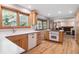 Bright kitchen with natural wood cabinets, hardwood floors, and an adjacent living area at 7351 S Sheridan Ct, Littleton, CO 80128