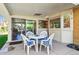 Covered patio features a round table with cushioned chairs near sliding glass doors to the sunroom at 7351 S Sheridan Ct, Littleton, CO 80128