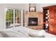 Main bedroom with a fireplace, balcony access, and built-in shelves at 3 White Pelican Cir, Thornton, CO 80241
