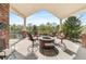 Covered outdoor patio with a fire pit and seating area, offering views of the lake and surrounding landscape at 3 White Pelican Cir, Thornton, CO 80241
