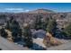 Aerial view of the home showing a large lot, mature trees, and mountain views in the distance at 2605 Crabapple Ct, Golden, CO 80401