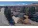 Aerial shot of property showcasing the roof, large lot, mature trees, and views of nearby mountains at 2605 Crabapple Ct, Golden, CO 80401