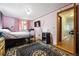 Pink bedroom featuring hardwood floors, a black and gray rug, and an open doorway at 6314 W 92Nd Pl, Westminster, CO 80031