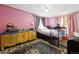 Pink bedroom featuring a black and gray rug, dresser, and adjustable bed frame at 6314 W 92Nd Pl, Westminster, CO 80031