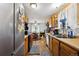 Kitchen with wooden cabinets and stainless steel refrigerator overlooking dining area at 6314 W 92Nd Pl, Westminster, CO 80031