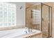 Luxurious bathroom with a soaking tub, glass block window, and tiled shower at 1272 S Milwaukee St, Denver, CO 80210