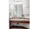 Bright bathroom vanity featuring decorative tile backsplash and wooden base with storage shelf at 1272 S Milwaukee St, Denver, CO 80210