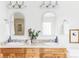 Bright bathroom featuring double sinks, arched mirrors, and natural wood cabinets at 1272 S Milwaukee St, Denver, CO 80210