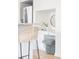 Built-in desk area with a chair, drawers, and a modern round mirror near the stainless steel refrigerator at 1272 S Milwaukee St, Denver, CO 80210