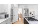 Kitchen showcasing stainless steel appliances, gas cooktop island, white cabinets and countertops, and wood flooring at 1272 S Milwaukee St, Denver, CO 80210