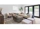 Bright living room featuring a comfortable sofa, neutral color palette, and natural light coming through doors and window at 1272 S Milwaukee St, Denver, CO 80210
