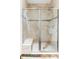 Elegant walk-in shower featuring neutral tile, glass doors, and a built-in bench for comfortable bathing at 1272 S Milwaukee St, Denver, CO 80210