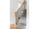 Modern staircase with gray carpeted steps, natural wood handrail, and black metal balusters at 1272 S Milwaukee St, Denver, CO 80210