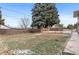 Large backyard features a chain link and wood fence, along with mature trees and a cement patio area at 4731 W 66Th Ave, Arvada, CO 80003