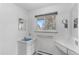 Bright bathroom with white tile, a vanity, and natural light from the window at 4731 W 66Th Ave, Arvada, CO 80003