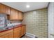 Kitchenette features tiled brick wall, wooden cabinets, sink and red countertops at 4731 W 66Th Ave, Arvada, CO 80003