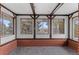 Cozy sunroom featuring a brick accent wall, wood beams, and large windows at 4731 W 66Th Ave, Arvada, CO 80003