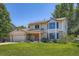 Charming two-story home featuring manicured front lawn, brick accents, and an attached two-car garage at 20596 E Shefield Ct, Parker, CO 80138