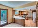 Well-lit kitchen featuring wood cabinets, white countertops, and access to the outdoor patio at 20596 E Shefield Ct, Parker, CO 80138